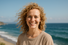 a smiling woman with light blonde curly hair on the seaside. potratrait